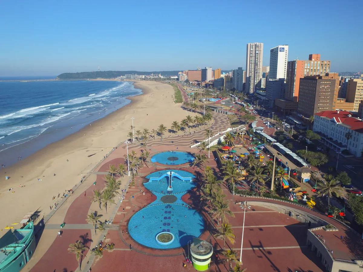 Aerial view of Durban's Golden Mile beachfront with palm-lined promenade, pools and the beach